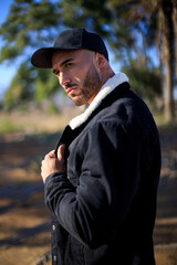 El cuerpo masculino perfecto - Impresionante culturista posando con gorra en la naturaleza. Chico joven musculado. Espacio para texto