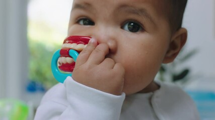 portrait cute baby with funny pacifier sucking on dummy at home