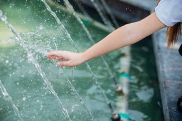 A little girl, an elementary school student, is playing merrily near the fountain .