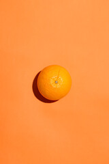 Top view of an orange fruit on orange background.
