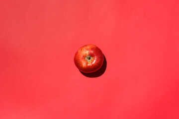 Red apple isolated in studio with red background