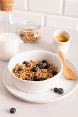Healthy breakfast with crunchy granola with blueberries in a white bowl