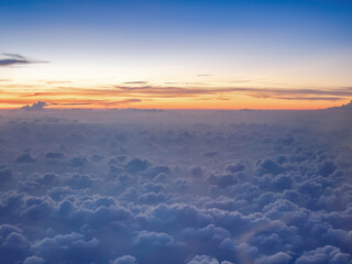 above the clouds twilight sky on high attitude level from airplane, fluffily clouds like heaven