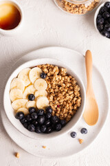 Muesli with banana and berries for breakfast in a bowl