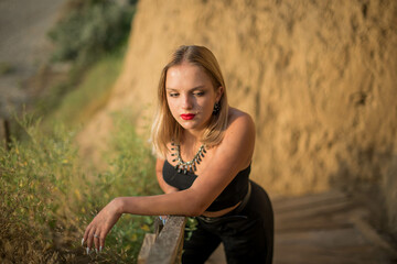 Naklejka premium Fashion woman. Cute teenage girl or woman on the beach nature landscape fresh air beach. Natural beauty. lifestyle, real people. Bright make up, red lips.