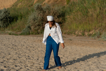 Сute teenage girl or woman wearing blue pants, white shirt, white bandana on the beach nature landscape fresh air beach. Natural beauty. lifestyle, real people, funny, dance.