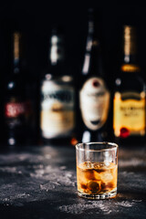 Whiskey with ice on a dark table