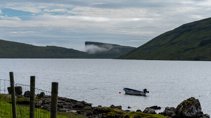 Fototapeta na wymiar Beautiful view of the Faroe Islands landscape of lakes, ocean, fishermans villages, and boats