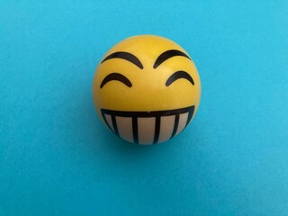 Pelota happy face amarillo sobre fondo azul