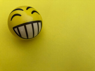 Pelota happy face amarillo sobre fondo amarillo