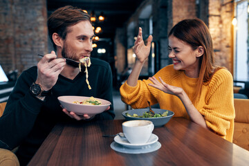 young couple sitting in a restaurant chatting dating