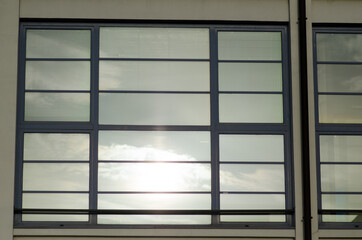 House: window with mirrored glass that reflects the sun. The building consisting of double glazing of superior energy class.
