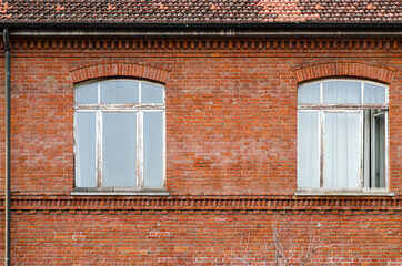 house: Windows worn by time on a brick facade of an ancient and valuable building.