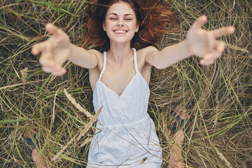 cheerful Woman in a white dress lies on the grass life leisure freedom