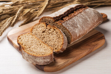 Fototapeta na wymiar Homemade rye ciabatta bread ready to eat. Spikelets of rye in a background.