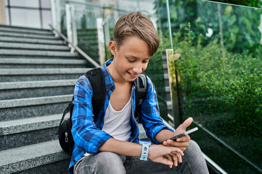 Little boy using blue kid smart watch and mobile phone