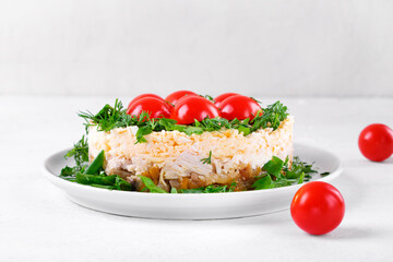 Layered salad with chicken, cheese, eggs and fried mushrooms topped with cherry tomatoes and herbs. Red Riding Hood salad. Russian cuisine
