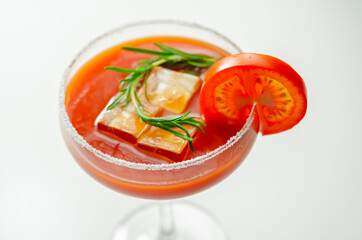 Bloody Mary cocktail prepared with pure vodka, tomato juice and hot pepper sauce, drink decorated with a slice of tomato