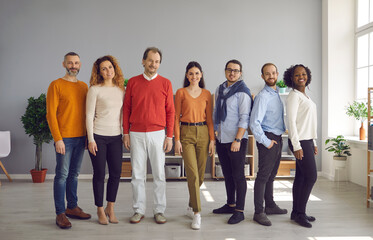 Diverse people group of different ages, race ethnicity nationality stand in line posing for camera. Professional business team workers staff. Office studio full body shot. Gender and racial equality