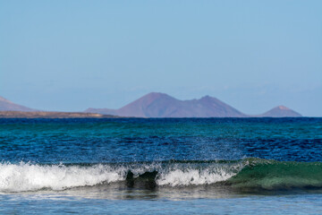 Black lava rocks and water waves of Atlantic ocean, nature landscape on Lanzarote, Canary islands, Spain