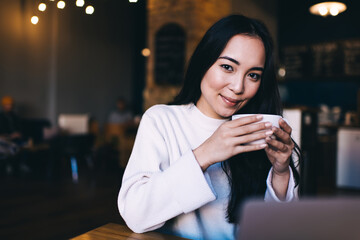 Female Asian freelancer sitting at cafe