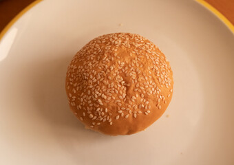 Sesame seed hamburger bun whole piece on plate ready