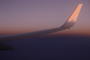Plain wing against beautiful sunset. Flight from Amsterdam to Helsinki.