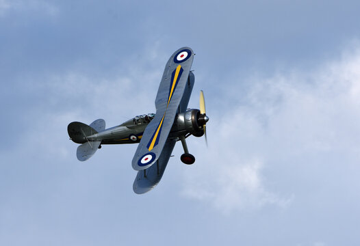ICKWELL, BEDFORDSHIRE, ENGLAND - SEPTEMBER 06, 2020: Vintage Gloster Gladiator aircraft in flight with cloud and blue sky background 
