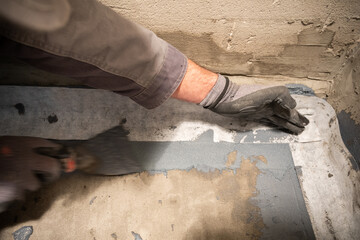 Applying a waterproofing tape to the joint between the wall and the floor. Internal construction...