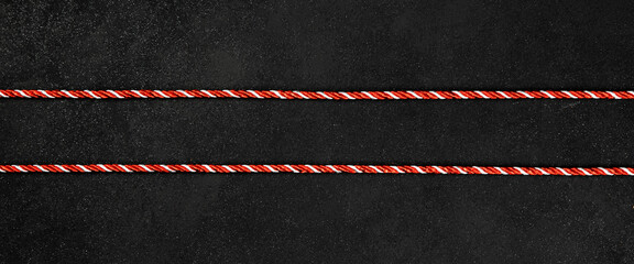 A row of red twine on a black background. Christmas package. Rope christmas.