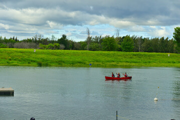 Boucherville, QC, Canada, 7-30-2021, three adults are kayaking in Lawrence (Laurent) River, islands of Boucherville national park on a cloudy summer day. Family, fun, together, team concepts.