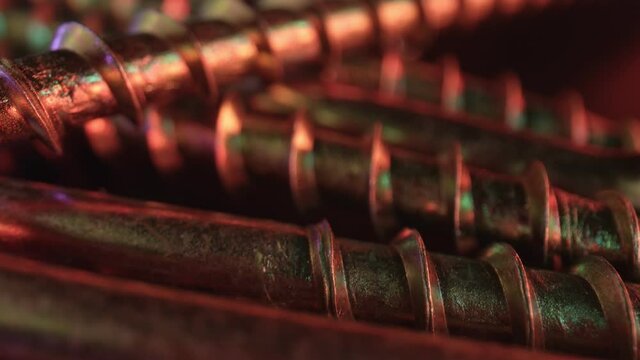 Several screws with yellow zinc coating on a dark surface. The concept of using the fastening for soft materials - wood, plastic. High quality. 4k footage.