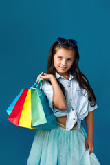 happy little caucasian child girl holds many shopping bags