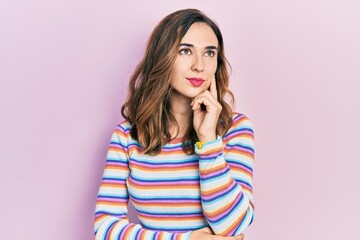 Young hispanic girl wearing casual clothes with hand on chin thinking about question, pensive expression. smiling and thoughtful face. doubt concept.