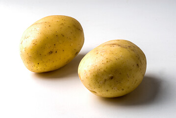 Potatoes on white infinite background with shadow on the side.