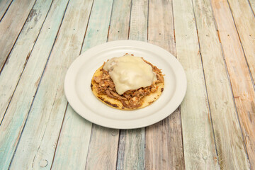 Colombian style corn arepa with shredded beef and lots of melted cheese on top