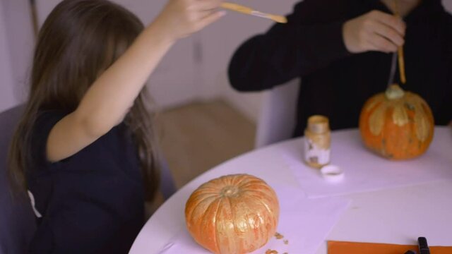 Cute girls are painting halloween pumpkins