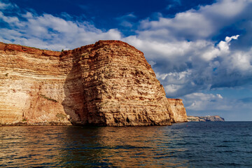 Black Sea red rocks coastline. Coastal red rocks and blue sea. Seascape. Summer. Traveling.