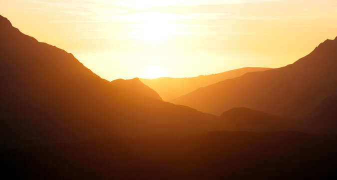 Fototapeta Stunning golden orange sunset in Snowdonia mountains, background.