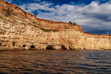 Black Sea red rocks coastline. Coastal red rocks and blue sea. Seascape. Summer. Traveling.