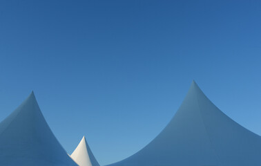 Cone shaped tents against clear blue sky, minimalism concept