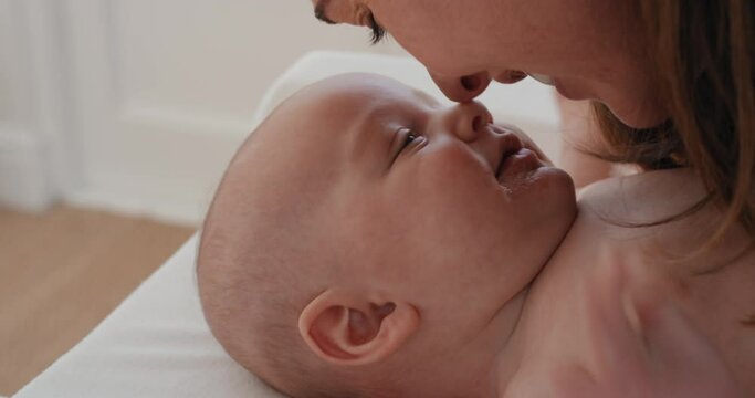 close up mother kissing baby laughing enjoying loving mom nurturing her toddler showing love at home