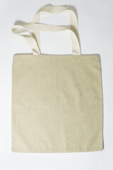 Eco-friendly empty beige canvas bag on gray background. Reusable Bag for Groceries and Shopping. Design Template for Mock-up. Front View