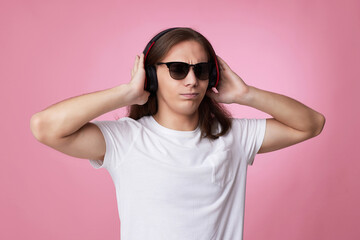 man in sunglasses listens to music with headphones and dances