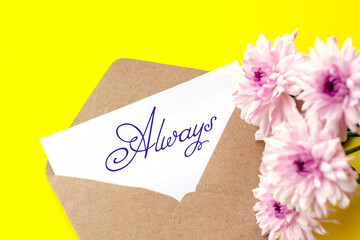 Love envelope and letter with written word always with pink chrysanthemum flowers on bright yellow bacground.