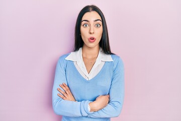 Fototapeta premium Beautiful woman with blue eyes standing over pink background afraid and shocked with surprise expression, fear and excited face.
