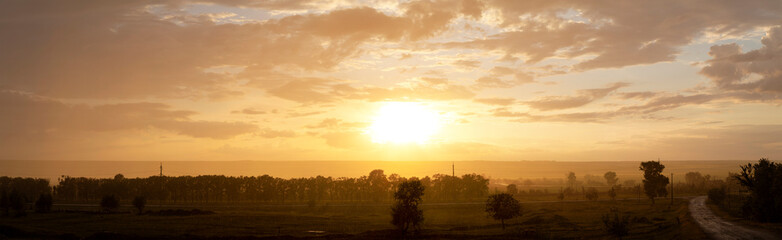 Rain pours down on the village. Landscape at sunset. Tragic gloomy sky. Panorama.