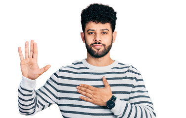 Young arab man with beard wearing casual striped sweater swearing with hand on chest and open palm,...