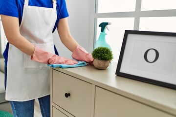 Woman cleaning table using rag and diffuser at home.