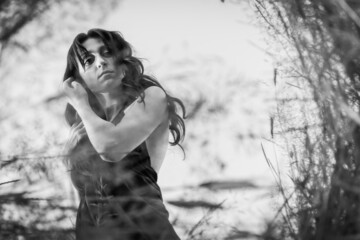 pretty brunette with long hair and looking at her reflection in the mirror between the grass....